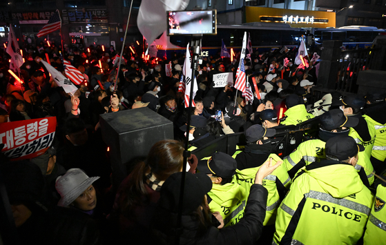 서울 마포구 서울서부지방법원에서 18일 '내란 우두머리' 혐의를 받는 윤석열 대통령이 구속 전 피의자 심문(영장실질심사)을 받고 있는 가운데 지지자들이 법원 담장 너머로 시위를 하고 있다. 임현동 기자