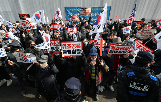 내란 우두머리 혐의로 체포된 윤석열 대통령의 영장실질심사가 열린 18일 오후 서울 마포구 서울서부지방법원에서 윤 대통령의 지지자들이 법원 담장 바깥에서 영장심사 규탄 집회를 하고 있다. 뉴스1