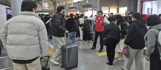 지난 17일 오전 7시쯤 김해국제공항 국제선 청사에 사람이 몰려 일부 구간에 병목현상이 생기자 직원이 통행 순서를 통제하고 있다. 김민주 기자