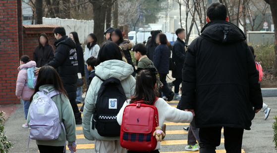 지난해 3월 14일 오전 서울 한 초등학교에서 학부모들이 아이들을 등교시키고 있다. 뉴스1