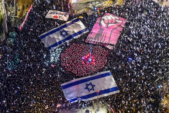 지난 2023년 3월 11일 텔아비브에 모인 시위대가 ‘사법부 무력화’에 저항하며 이스라엘 국기를 펼쳐 들었다. 이들은 네타냐후 정부의 사법 개혁안이 독재로 이어질 수 있다며 반대했다. 로이터=연합뉴스