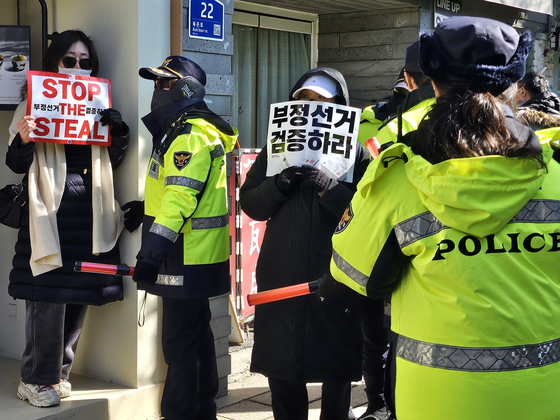 13일 헌법재판소 앞에서 경찰이 손팻말을 들고 있는 윤 대통령 지지자들에게 해산명령을 하고 있다. 서지원 기자