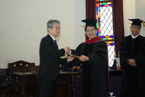 16일 일본 교토 도시샤대에서 윤동주 시인의 명예박사 학위 수여식이 개최됐다. 도시샤대 고하라 가쓰히로 학장(오른쪽)이 윤동주 시인의 조카인 윤인석 성균관대 명예교수(왼쪽)에게 명예박사 학위증을 수여한 뒤 악수를 나누고 있다. 사진 주오사카총영사관