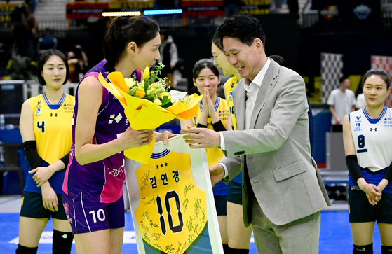 강성형 감독(오른쪽)이 건네는 은퇴 기념 꽃다발을 받으며 기뻐하는 김연경. 사진 한국배구연맹