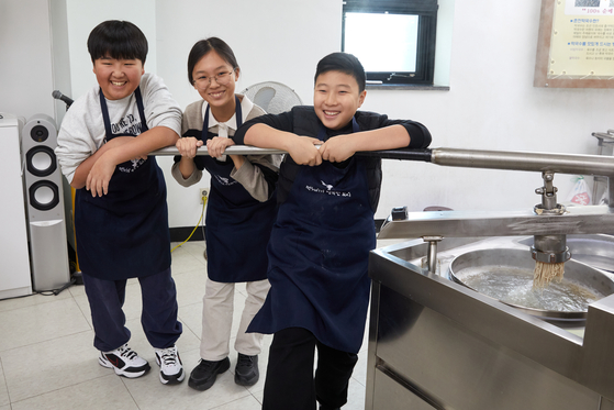 막국수틀에 반죽을 넣은 후 손잡이를 잡고 지긋이 누르면 면발이 나온다. 막국수틀을 잡고 힘껏 누르는 소중 학생기자단. 