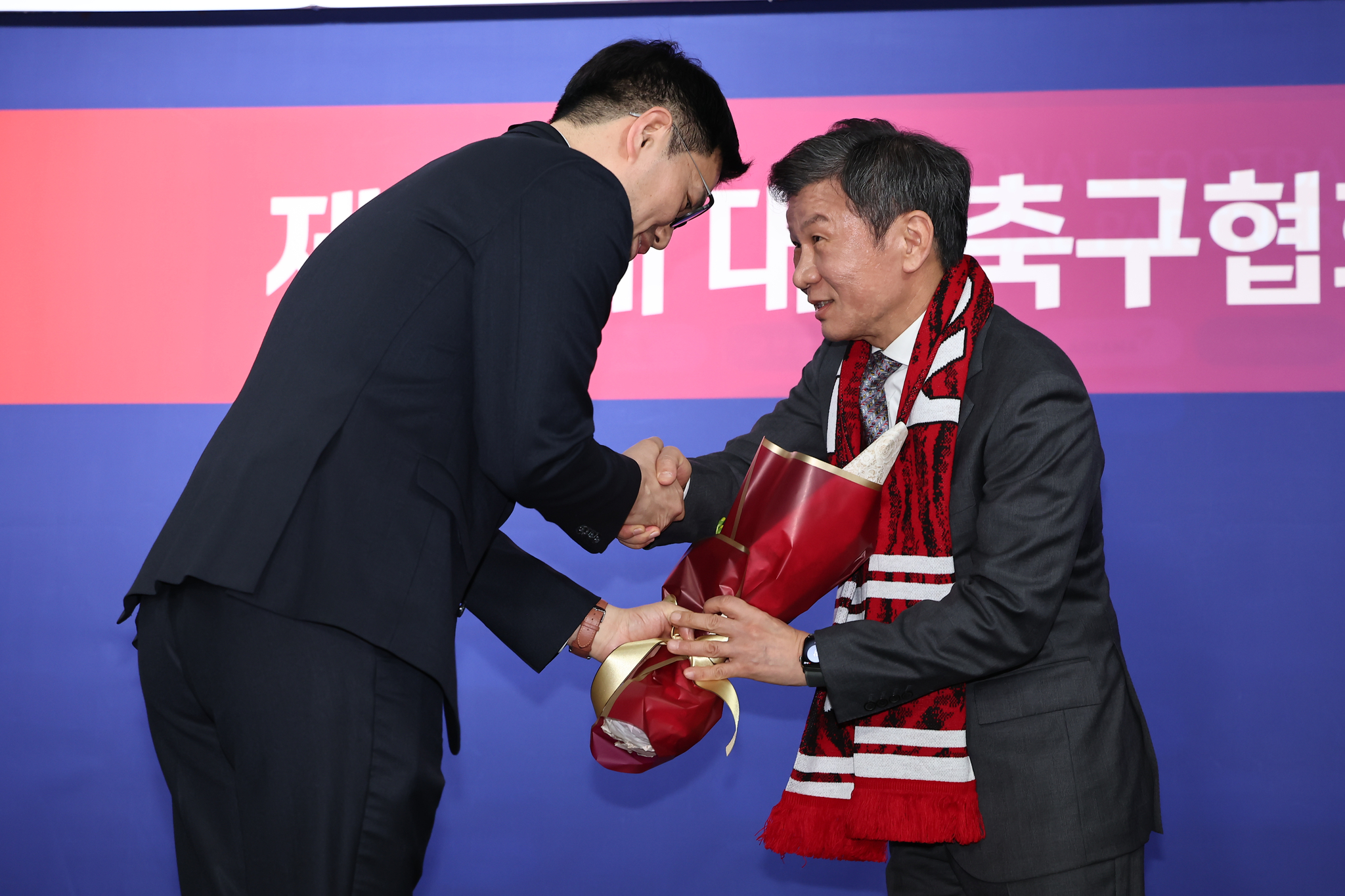 정몽규 (오른쪽) 신임 회장이 26일 오후 서울 종로구 축구회관에서 열린 제55대 축구협회장 선거에서 당선 후 꽃다발을 받고 있다. [뉴스1]