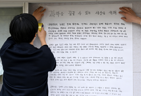 지난해 '학위수여식 R&D 예산 복원 요구 입틀막 강제퇴장에 대한 대학생·졸업생 대책위원회 공동대표'를 맡은 채동주 한국과학기술원(KAIST) 21학번 학생이 대전 유성구 카이스트에 대자보를 붙이고 있다. 뉴스1