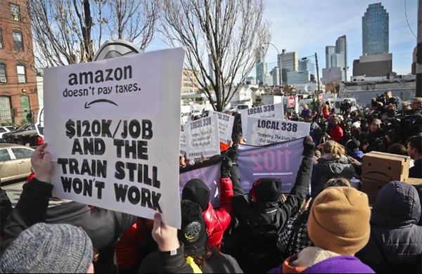 11월 14일, 뉴욕에서 열린 반-아마존 시위에서 시위자들이 포스터를 들고 다니면서 뉴욕이 HQ2 개발을 위해 보조금을 주는 것을 반대하고 있다.