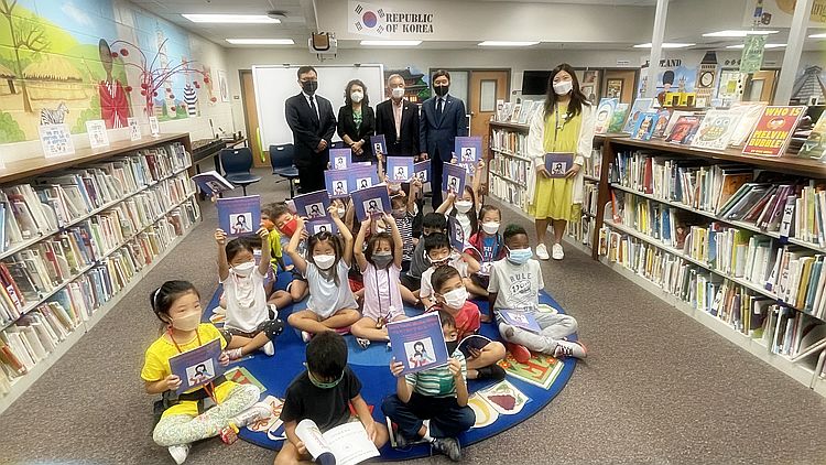 9일 스와니 파슨스초교에서 증오범죄 비대위 관계자들과 임슬기(뒷줄 오른쪽 첫 번째) 교사가 지켜보고 있는 가운데 어린이들이 선물 받은 책을 보여주고 있다.