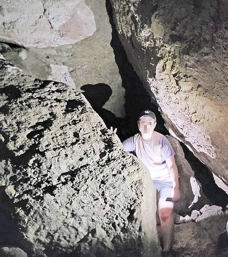 한 등산객이 마운틴 피너클스 발코니 케이브 트레일 구간의 자연동굴을 빠져나오고 있다. 