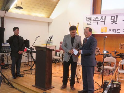 오정방 한인 회장이 김병철 체육회자에게 발전 기금을 전하고 있다.