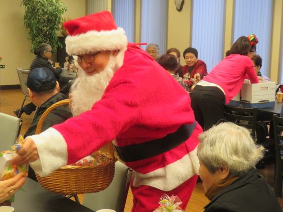 산타로 분장한 김동식 봉사자가 참석자들에게 선물을 전하고 있다.