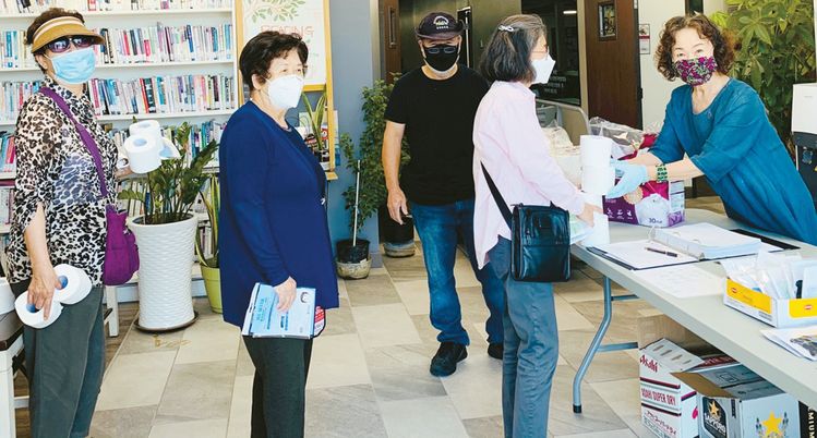 지난 21일 가든그로브의 OC한인회관을 찾아온 한인들이 마스크와 화장지를 받아가고 있다.     [OC한인회 제공]