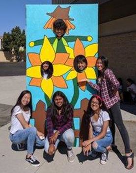 Whitney High students pose in front of the western posters for a photo opportunity. [Source:  Whitney High School Official Twitter account]