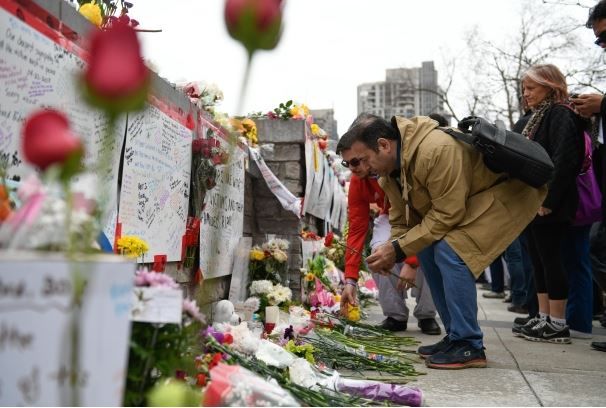 작년 4월 노스욕 미니밴 테러 사건이 발생한 직후 주민들이 현장 인근에 마련된 추모 장소에 꽃을 놓고 있다.