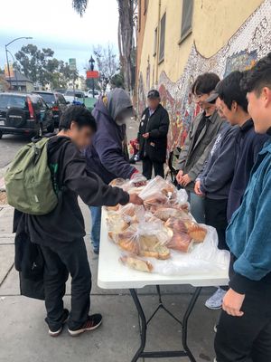 샌디에이고 한인 학생들이 노숙자에게 빵과 음료를 나누고 있다. [독자 제공]