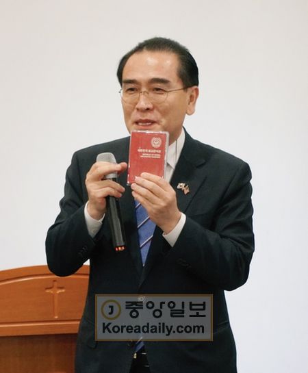 태영호 의원이 한국의 외교관 여권을 들어보이며 북한의 외교관 여권과 비교하고 있다.