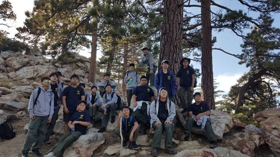 Troop 173 is also shown stationed here at one of the notches on the hike with the natural view of trees and rocks in the background.