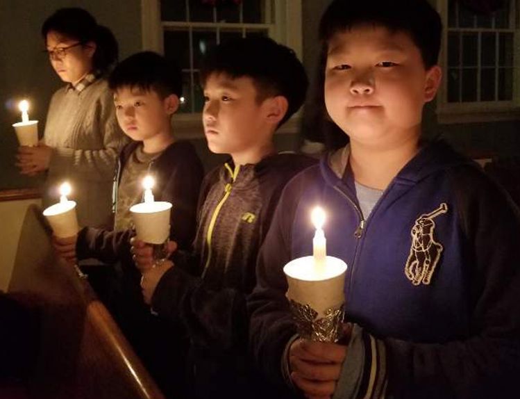 뉴욕겟세마네교회 송구영신 예배에 참석한 어린이들이 촛불을 들고 기도한 후 함께 서 있다. [사진 뉴욕겟세마네 교회]