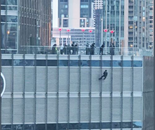 시카고 트럼프타워 16층 난간에서 한 남성이 밧줄에 매달려 있다. [트위터 갈무리]