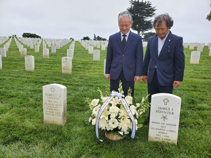 포트 로스크랜스 국립묘지를 방문한 박경재 LA총영사와 백황기 한인회장이 장진호 전투에 참전해 전사한 한 용사 묘지에 헌화한 뒤 묵념하고 있다. 
