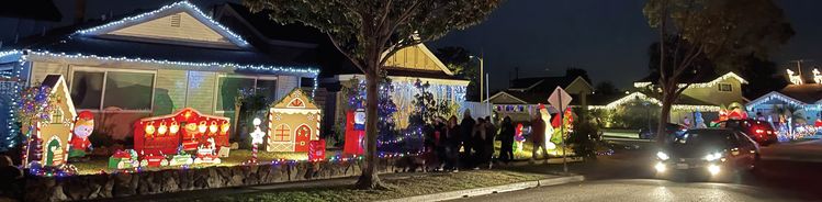 지난 21일 터스틴 레드힐 애비뉴 인근 올윈, 라버넘 드라이브를 찾아온 이들이 주택들의 성탄 장식을 구경하고 있다.