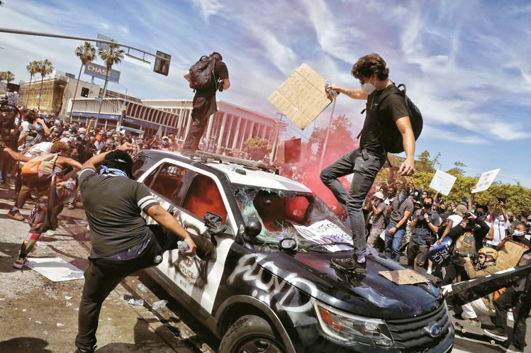 30일 LA 한인타운 서쪽 방향 베벌리 불러바드 일대에서 벌어진 시위현장에서 시위대가 LAPD 소속 경찰차량을 부수고 있다. 이날 3대의 경찰차량이 전소됐고 수십대의 경찰순찰차들이 훼손됐다. [김상진 기자]