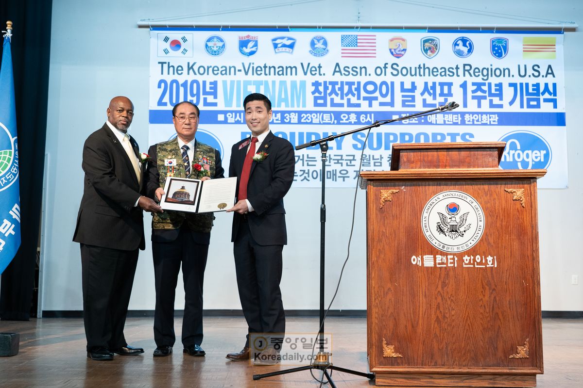 마이클 글랜턴(왼쪽), 샘 박(오른쪽) 주하원의원이 이춘봉 회장에게 조지아 주하원 한국군 베트남전 참전 결의안을 전달하고 있다.