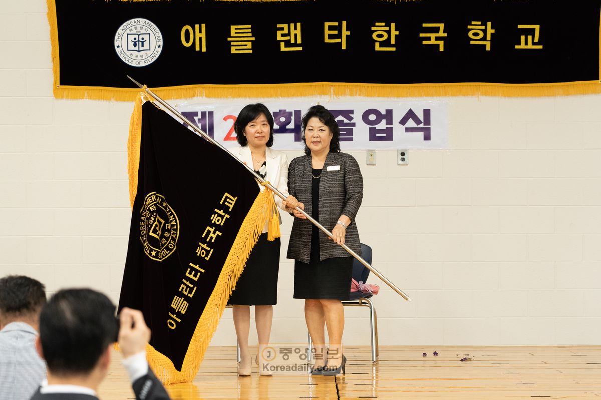 이날 취임한 김현경(왼쪽) 제14대 교장이 송미령 이임 교장에게 교기를 전달받고 있다.
