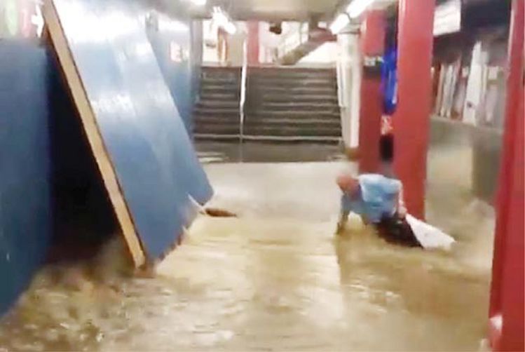 지난 17일 퀸즈 코트스퀘어 전철역 플랫폼에 서 있던 한 남성이 폭우로 갑자기 들이닥친 물살에 밀려 열차가 들어오고 있던 선로쪽으로 떠내려가다 겨우 빠져나오고 있다. [사진 SubwayCreatures 인스타그램 동영상 캡처]