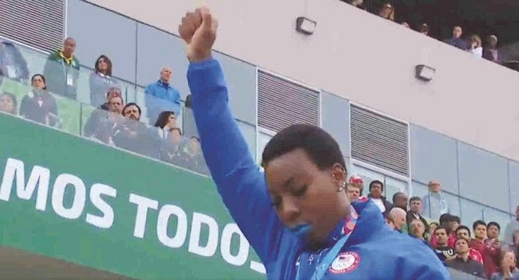 10일 팬암대회 여자 해머던지기 시상식에서 금메달을 딴 그웬 베리가 국가가 올려지는 동안 주먹 쥔 오른손 들어올리며 항의하고 있다. [트위터]