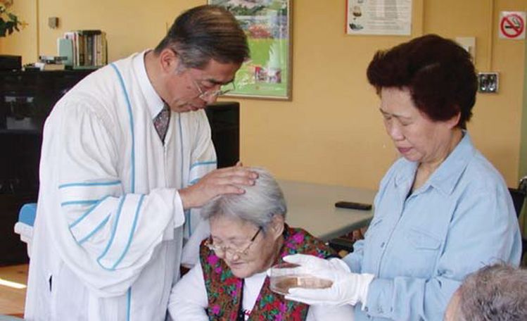 한국요양원 박영표 목사(왼쪽)가 한 한인 노인에게 안수하고 있다.