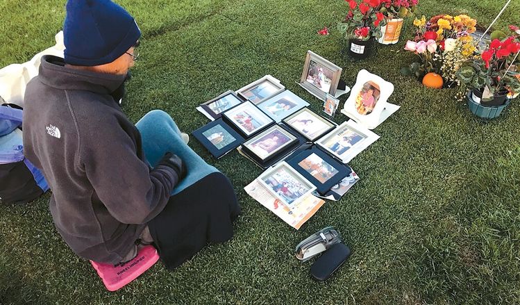 아내와 사별한 김진완씨가 묘지에서 아내 사진을 보며 생각에 잠겨있다.