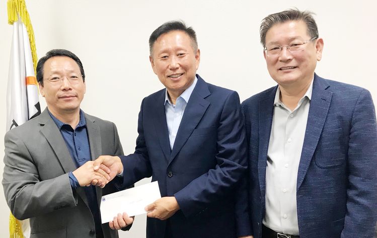 라이온스클럽 전현식(가운데) 회장, 유대향(오른쪽) 총무가 김장호 해피빌리지 국장에게 사랑의 마당축제 후원금을 전달하고 있다.