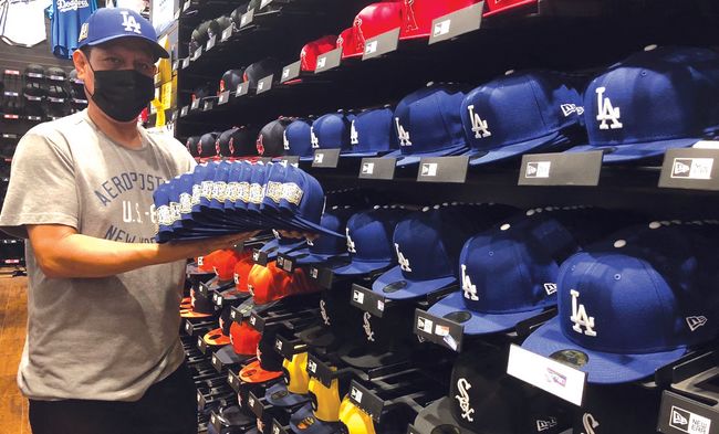 LA 다운타운의 스포츠용품 도매점 ‘프로베이스’의 직원이 월드시리즈 패치가 달린 LA 다저스의 정품 모자를 선보이고 있다. [프로베이스 제공]