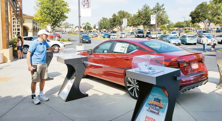 아웃렛마다 고객 유치경쟁이 치열하다, 7월 4일 미국 독립기념일을 맞아 카마리오 아웃렛을 찾은 소비자가 경품으로 나온 자동차를 들여다보고 있다.