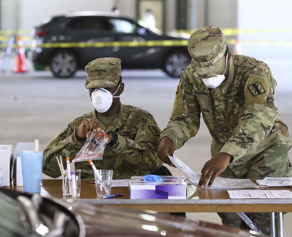 16일 콘이어스에 있는 코로나19 드라이브 스루 검사장소에서 미 육군 장병들이 의료 지원을 하고 있다. AP