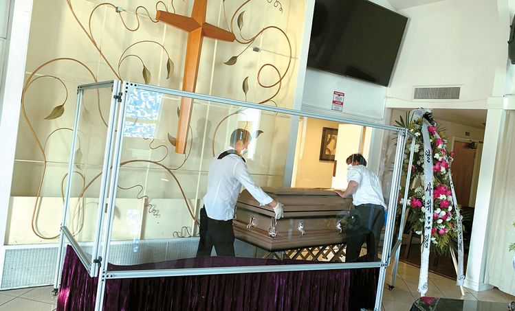 코로나 사망자가 증가하면서 한인 장례업계도 시신보관에 냉동트럭을 투입하는 등 비상 영업에 나서고 있다. 18일 한국장의사 직원들이 장례식장에 관을 옮기고 있다. 김상진 기자 