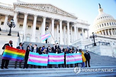 연방하원 민주당 소속 의원들이 '평등법안' 가결 후 의사당 앞에서 LGBTQ&#8226;트랜스젠더 프라이드 깃발을 들고 기념하고 있다. [로이터=연합뉴스] 