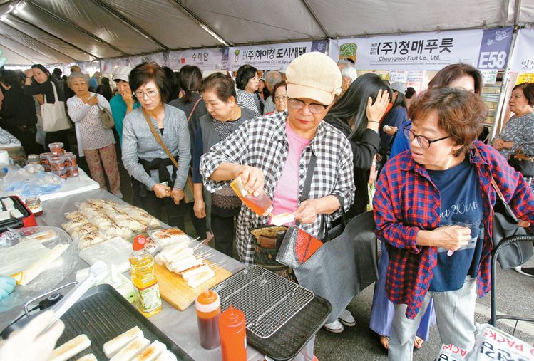 장터에서 많은 관객들이 한국 곳곳의 특산물을 구입하고 있다.