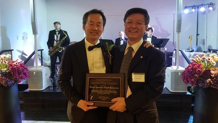 김필성(오른쪽) 회장이 미국치과의사협회장 상을 받고 기뻐하고 있다.