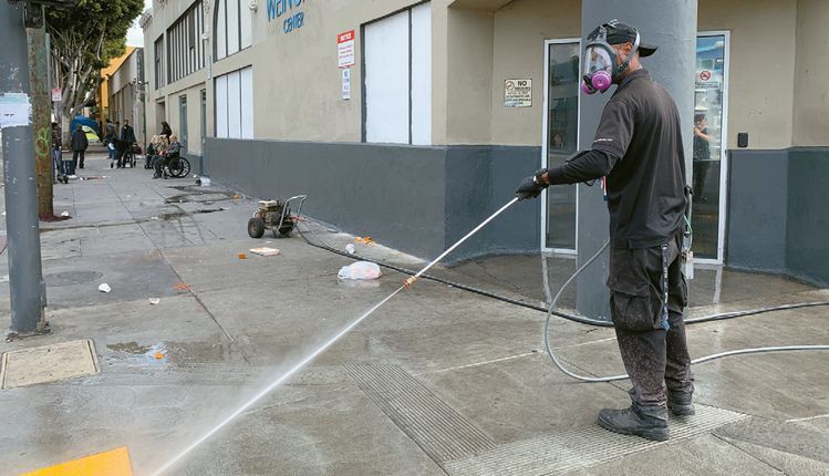 방독면 쓰고 물청소…15일 오전 LA다운타운스키드로 거리를 홈리스 시설 직원이 방독면을 쓴채 물청소하고 있다.
