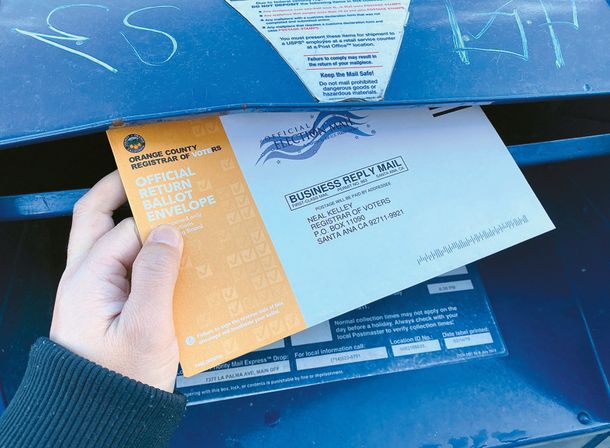 지난 2일 한 유권자가 우편투표지 회송용 봉투를 우체통에 넣고 있다.   박낙희 기자