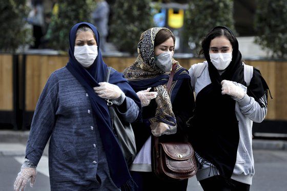이란에서 신종 코로나가 확산하자 23일(현지시간) 이란인들이 마스크와 장갑을 착용한 채 걷고 있다. 