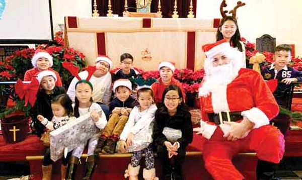 롱아일랜드에 있는 '뉴욕말씀장로교회'에서 성탄 특집 연극 공연이 끝난 후 산타복장을 한 남자 성도가 어린이들에게 선물을 나눠주며 함께 포즈를 취했다.