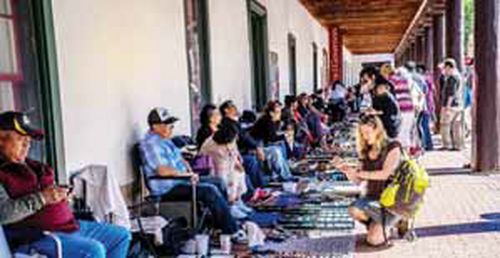 산타페 총독관저 앞에 있는 원주민 노점에서 각종 수공예품을 고르고 있는 관광객.