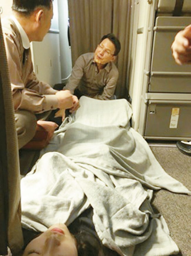 아시아나항공 기내에서 한청수 원장(오른쪽)과 승무원이 쓰러진 여성이 의식을 되찾도록 응급조치를 하고 있다. [사진=한청수 원장 제공] 