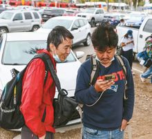 2024년 6월 중국 국적자 장하오(Zhang Hao)가 샌디에이고 교통역에서 휴대폰을 이용해 택시를 호출하고 있다. 그는 국경순찰대 요원들에 의해 다른 수십 명의 망명 신청자들과 함께 이곳에 내려졌다. [로버트 고티에 / LA 타임스]